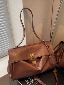 Classic brown leather tote bag with gold swivel lock and adjustable shoulder strap
