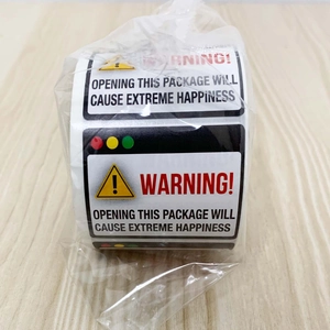 Macro detail of funny roll-up warning stickers with extreme happiness message on wood