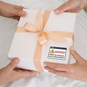 Gift box with champagne ribbon and creative Warning Opening This Package labels