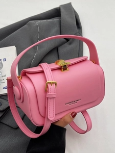 Pink minimalist cylindrical crossbody bag with gold shell buckle and thin shoulder strap