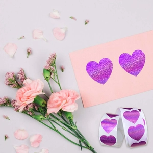 Detailed close-up of purple glitter heart stickers on a romantic card with flowers