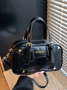 Glossy black faux leather boston bag with gold handles and adjustable shoulder strap