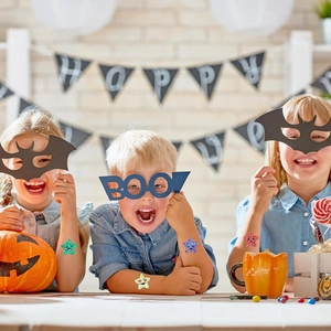 Close-up of glitter star stickers with smiley faces on children's arms for Halloween party
