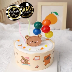 Detail of graduation cake toppers with Congrats Grad plaques and mini balloons