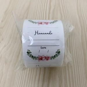 Close-up of Homemade floral stickers roll with date lines for food labels