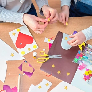 Flat lay of colorful star and heart stickers with DIY craft tools for creative kids projects