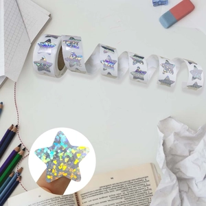 Macro shot of laser star stickers on a roll with stationery on a desk setup