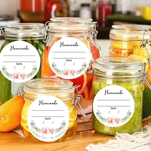 Macro shot of circular Homemade floral stickers with date labels on glass food jars