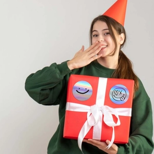 Adesivi olografici emoji su scatola regalo, con design di sorrisi e facce buffe
