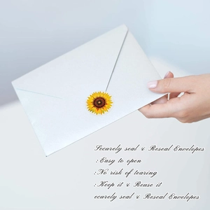 Close-up of yellow sunflower thank you labels on a white envelope sealing a gift