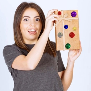 Colorful glitter round reward stickers set on brown gift box held by a female model