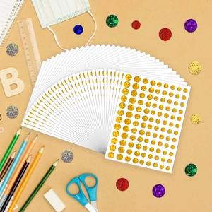 Detail view of round gold glitter reward stickers with crafting scissors and rulers
