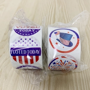 Close-up of I Voted Today stickers rolls with American flag motifs on wooden background
