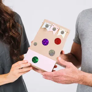 Close-up of glitter laser reward stickers on a kraft gift box held by hands