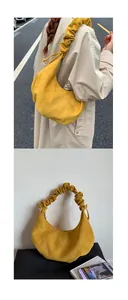 Detail der gelben Wildledertasche mit verstellbarem, gerafftem Schulterriemen im Cloud-Look