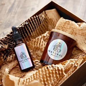 Detailed laser thermal labels on amber glass bottle and candle jar in a gift box