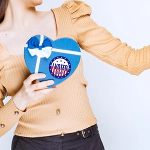 Detail of round 'I VOTED TODAY' sticker on a blue heart-shaped gift box with white ribbon