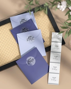 Detail of purple envelopes and transparent wedding stickers on a stylish bamboo tray