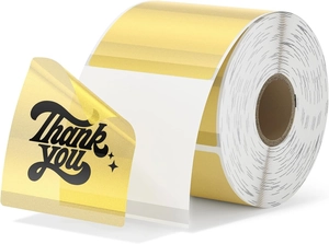 Macro shot of gold metallic Thank You stickers on roll with black cursive typography