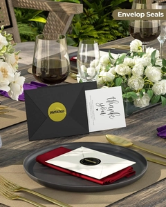 Macro view of gold and black invitation envelope seal stickers on a formal dining table
