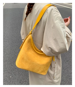 Close-up of a vintage yellow faux suede large capacity shoulder bucket bag
