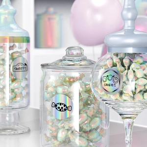 Roll of thermal holographic adhesive stickers on three elegant glass candy jars