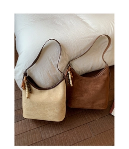 Close-up of vintage suede shoulder bags in beige and brown with beaded charms