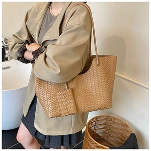 Detailed view of khaki woven tote bag showing cross-weave texture and small purse attachment