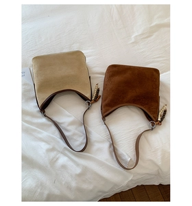 Detail shot of two vintage suede bucket bags in beige and dark brown color options