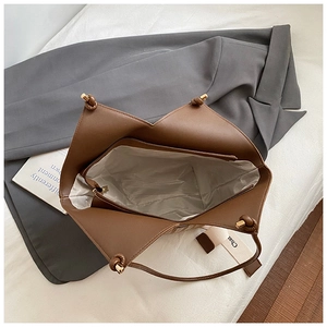 Detail view of dark brown tote bag with gray lining and internal zipper pocket