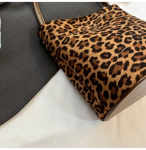 Détail du sac à imprimé léopard avec finitions en cuir marron et texture suédée douce