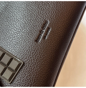Detail of dark brown leather texture with Fashion & Modern embossed logo and grid pattern