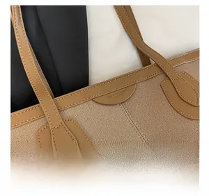 Detail of light brown canvas tote with leather handles and fine stitching craftsmanship