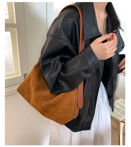 Close-up of a brown suede hobo tote bag with minimalist semi-circular vintage design