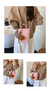 Sac seau rose avec breloque ours, porté en bandoulière et à la main par le mannequin