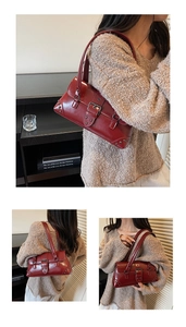 Detail of dark red vintage leather shoulder bag featuring silver studs and buckle strap