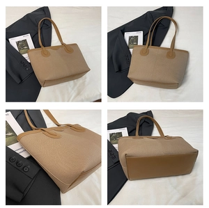Detail view showing oatmeal canvas and brown leather stitching on tote bag with long handles