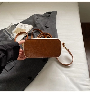 Detail view of the vintage oil-waxed leather bucket bag base with metallic gold hardware