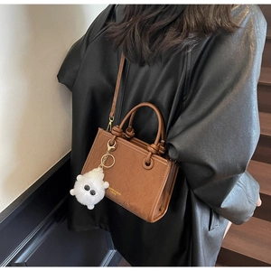Sac seau marron en similicuir avec pompon en peluche et bandoulière amovible