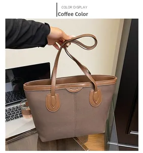 Detail of coffee brown canvas tote bag with leather stitching and fashion logo tag