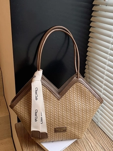 Brown woven tote bag with V-shaped top and silk ribbon on a sunny wooden stair