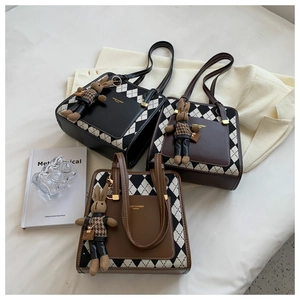 Detailed view of three quilted tote bags with cute bunny charms and brand logo
