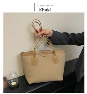 Detail view of khaki large capacity tote bag with canvas body and leather trim accents