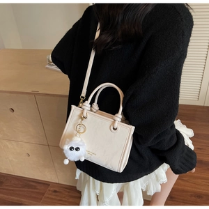 Sac seau bandoulière crème chic avec breloque en peluche dans un cadre de vie