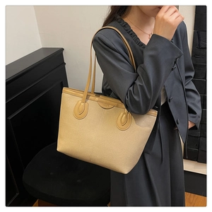 Detailed macro view of large tote bag showing durable canvas texture and leather trim finish