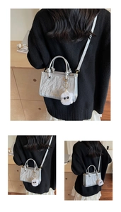 Détails du sac bandoulière argenté froissé avec un porte-clé en peluche blanche