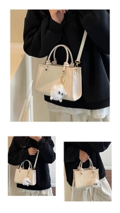 Détail du mini sac cabas crème avec doubles poignées et breloque en peluche blanche douce