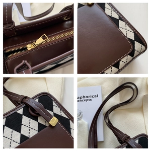 Detail view of gold metal zippers and premium brown leather with contrast stitching