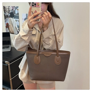 Close-up of a dark brown matte tote bag with smooth leather straps for office commute