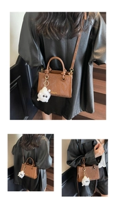 Sac seau vintage en cuir marron avec charme de monstre en peluche blanc et texte embossé